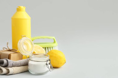 Gri arka planda kabartma tozu bulunan doğal temizlik malzemeleri.
