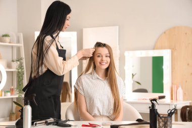Genç bir kadın kuaförde saç eklettiriyor.