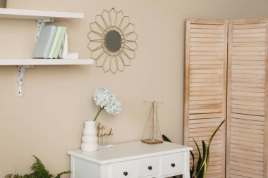 Çiçekli vazo ve dekorasyon renkli duvarın yanında.