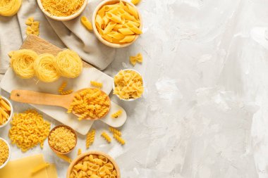 Açık arkaplanda farklı ham makarnayla kompozisyon