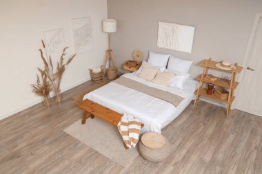 Rahat bir yatak ve yatak odasının içinde resimler.