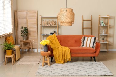 Oturma odasında ekose ve güzel nergislerle dolu rahat bir kanepe.