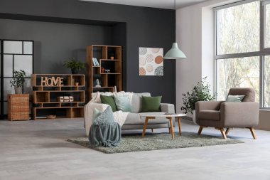 Şık oturma odasında rahat bir kanepe, koltuk ve ekose.