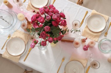 Güzel bir masa, pembe güller ve mumlarla. Düğün kutlaması için odada, üst manzara.