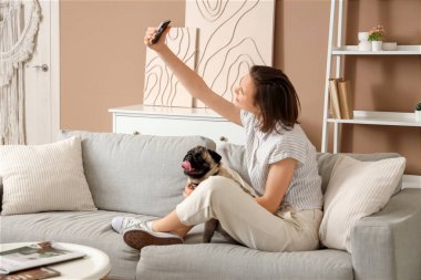 Şirin köpekli güzel bir kadın evde selfie çekiyor.