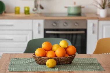 Mutfaktaki masada limon ve portakallı sepet.