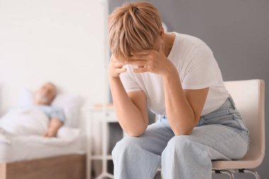 Üzgün olgun kadın ve hasta kocası yatak odasında.