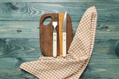 Gri ahşap arka planda masa, peçete ve çatal bıçak seti