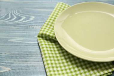 Gri ahşap zemin üzerinde tabak ve peçete ile masa ayarları