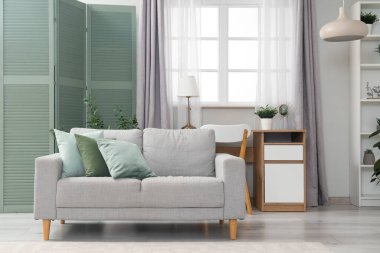 Yeşil perdeli, kanepeli ve masalı bir oturma odası.