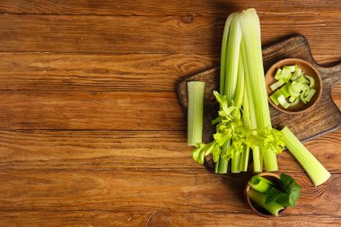 Ahşap zemin üzerinde taze yeşil kereviz olan yemek ve kaseler.