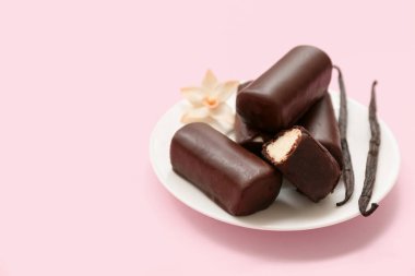 Pembe arka planda vanilya aromalı lezzetli çikolatalı kaymaklı aperatifler.