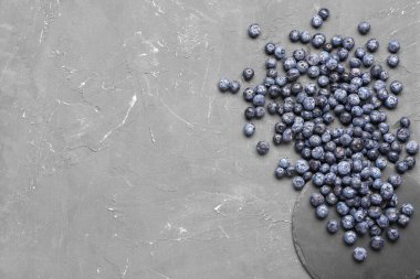 Gri arka planda tatlı taze yaban mersinli siyah tahta