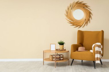 Rahat koltuğu, sehpası ve aynası olan minimalist bir oturma odası.