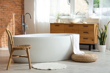 Banyonun içinde küvet, sandalye ve lavabo var.