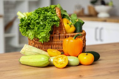Tahta mutfak tezgahında farklı taze sebzelerle dolu bir sepet.