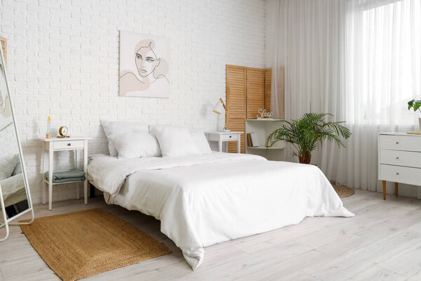 Интерьер современной спальни с мягкими подушками на уютной кровати