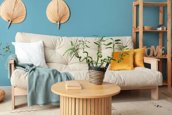 Kahve masası ve kanepenin üzerinde bambu sapları olan şık bir oturma odası.