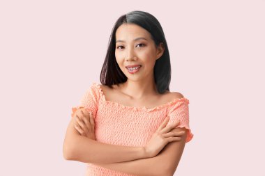 Pembe arka planda güzel bir Asyalı kadının portresi.