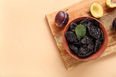 Turuncu arka planda kurutulmuş erikli kase