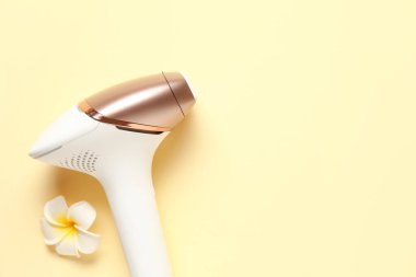 Soluk sarı arka planda güzel çiçekli modern fotoepilatör.