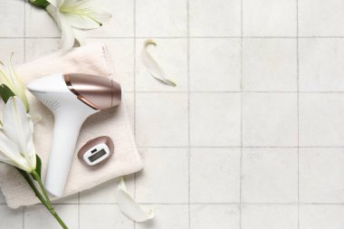 Eklenti, banyo havlusu ve beyaz fayanslı zambak çiçekleriyle modern fotoepilatör.