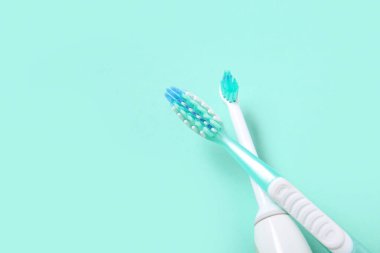 Arkaplanda elektrik ve plastik diş fırçaları.