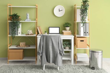 Çalışma yeri, raf üniteleri ve bitkileri olan şık bir ofis.