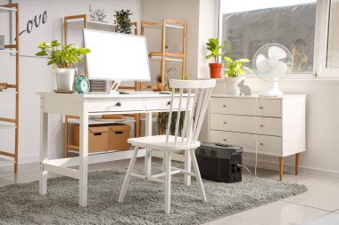 Modern bilgisayarlı rahat çalışma alanı ve çağdaş odada taşınabilir güç istasyonu