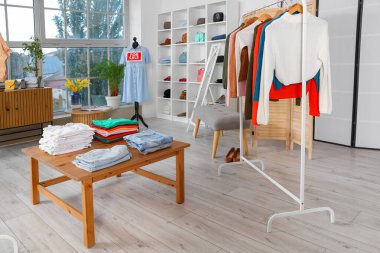 Askısı ve masası olan bir giyim mağazası.