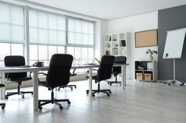 Toplantı için masa hazırlanmış modern ofisin içi.