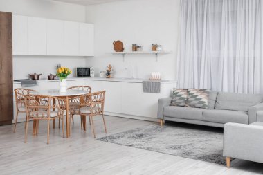 Modern mutfağın içinde yemek masasında lale vazosu olan bir vazo.