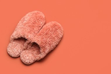 Kırmızı arka planda bir çift kırmızı yumuşak terlik. Üst görünüm