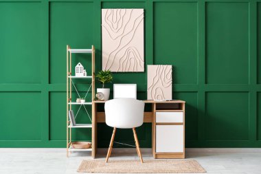 Çalışma odası, dizüstü bilgisayar ve yeşil duvarlı şık bir oda.