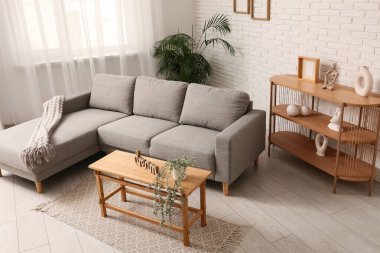 Konforlu kanepe ve kahve masası. Oturma odasında bitki ve kelime rüyası.