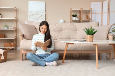 Kitap okuma ve evde katta oturan güzel genç kadın