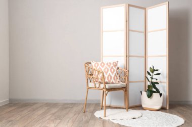 Katlanan ekran, koltuk ve bitki örtülü ışık odasının içi