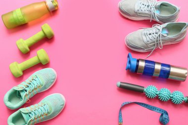 Pembe arka planda spor ayakkabıları ve spor malzemelerinden yapılmış çerçeve