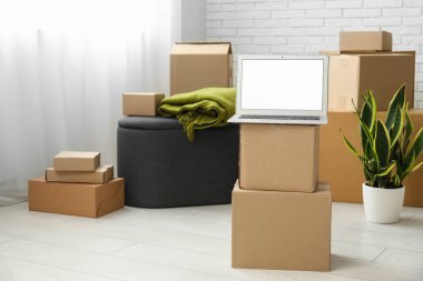 Işık odasındaki kutuları taşırken boş dizüstü bilgisayar