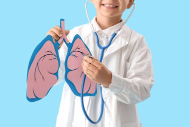 Steteskoplu küçük doktor ve mavi arka planda kağıt ciğerli, yakın plan.