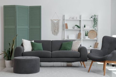 Gri kanepe, koltuk, kanepe, kanepe ve katlanır ekran ile modern oturma odasının içi.