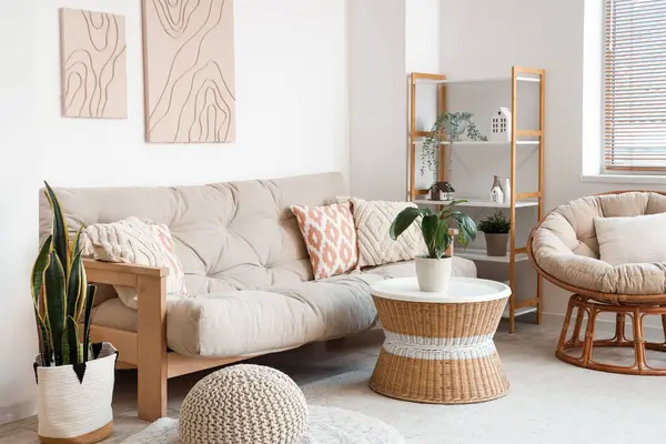 Rahat kanepesi, sehpası, çiçekleri, koltuğu ve resimleri olan modern oturma odası.