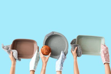 Eldivenler içinde kadın elleri ve mavi arka planda lezzetli çörekler.