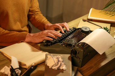 Klasik daktilosu olan genç bir yazar. Odada daktilo yazıyor. Yakın plan.