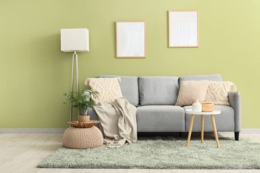 Ekoseli, yastıklı ve kahve masalı rahat bir kanepe.