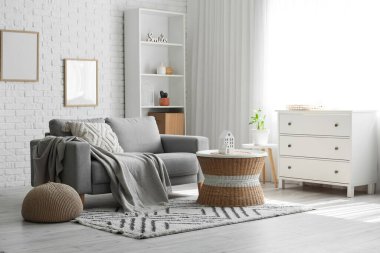 Oturma odasında ekoseli, yastıklı ve kahve masalı rahat bir kanepe.