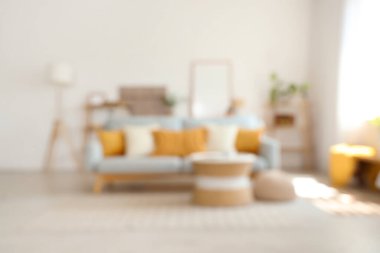 Kanepesi ve masası bulanık, modern aydınlık oturma odasının içi.