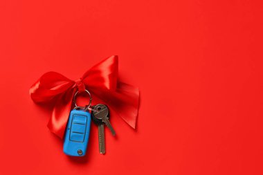 Kırmızı arka planı olan yeni arabanın hediye anahtarları.