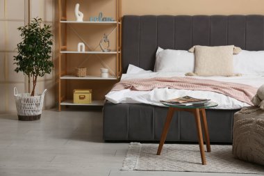 Büyük yataklı, raflı ve masalı şık bir yatak odası.