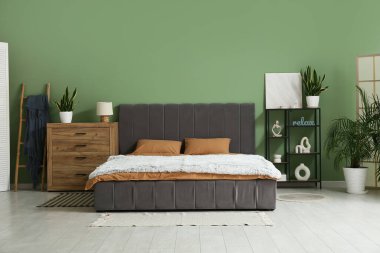 Şık modern yatak odası, temiz yatak odası, raf ünitesi ve ev bitkileri.